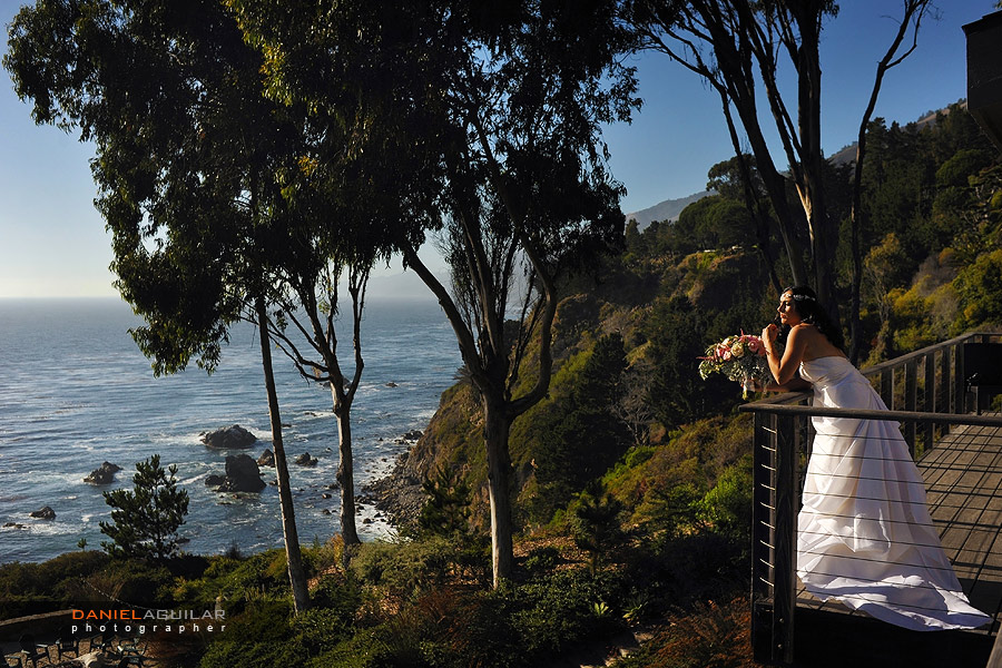A bride is looking at the ocean during sunset hour minutes before her ceremony starts at wind and sea estate in big sur