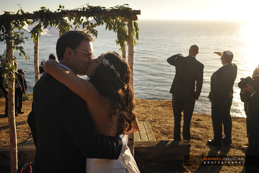 a bride and a groom kiss each other after their sunset wedding ceremony is over at wind and sea estate in big sur